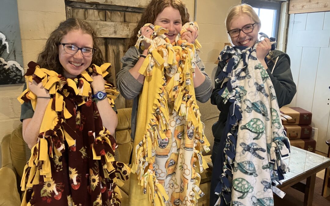 Students in the Roots discipleship cohort display blankets they made for a local pregnancy center.