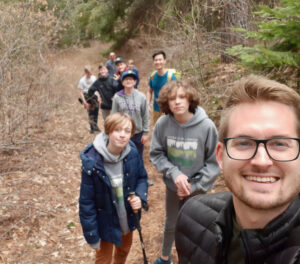 Youth leader and teens hike in a Washington forest