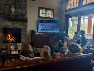 Teens gather around a cabin fire to sing praise and discuss the Heidelberg Catechism